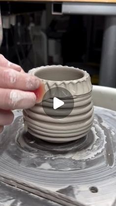 a person is making a bowl out of clay with their thumb on the top of it