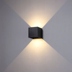 a wall mounted light on the side of a white wall