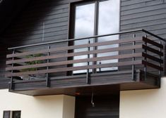 a black and white house with a wooden balcony