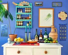 an old dresser with bottles and other items on it in front of a blue wall