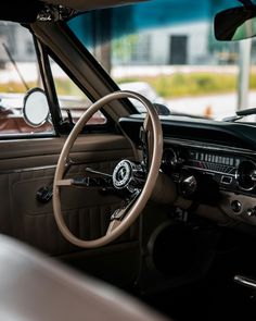 the interior of an old car with steering wheel and dashboard