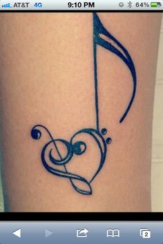 a tattoo on the leg of a woman with an arrow and musical note in the shape of a heart