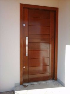 a wooden door in front of a white wall