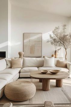 a living room filled with white furniture and a large tree in the middle of it