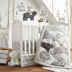 a baby crib in the corner of a room with white walls and wooden floors