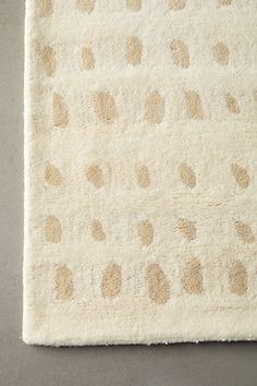 a white rug with brown spots on it