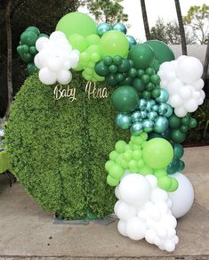 a green and white balloon arch with the word baby pha spelled out on it