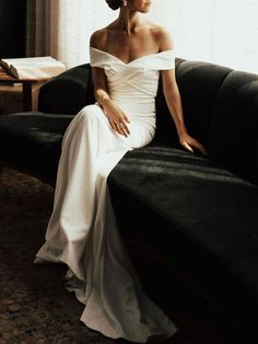 a woman in a white dress sitting on a couch