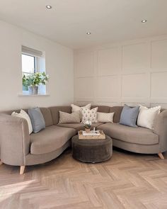 a living room filled with furniture next to a window and hard wood floored floors