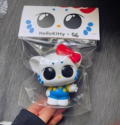 a person holding a hello kitty toy in their hand