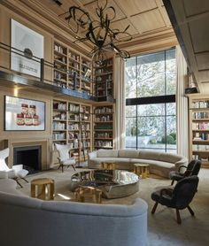 a living room filled with furniture and a fire place next to a book shelf full of books