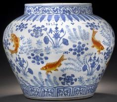 a blue and white vase with gold fish on it