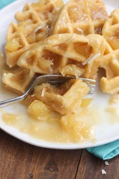 a white plate topped with waffles covered in syrup