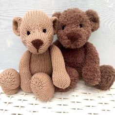 two brown teddy bears sitting next to each other on a white tableclothed surface