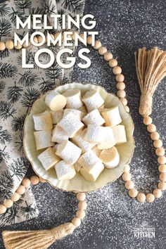 a bowl filled with marshmallows next to a wooden beaded tassel