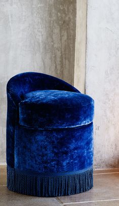 a blue chair sitting on top of a tile floor