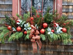 a window box decorated with christmas decorations and greenery