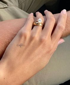 a woman's hand with a diamond ring on her left wrist and a man's arm behind her