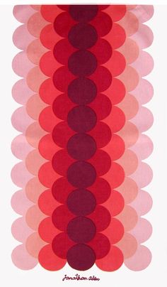 a red and pink wall hanging with circles on the bottom, in front of a white background