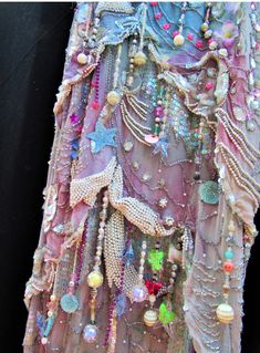 the back of a dress made out of beads and other things hanging from it's side