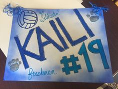 a blue and white name plate with paw prints on it that says kalli beeman 19