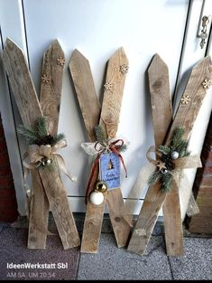 three wooden skis decorated with christmas decorations and ornaments on the side of a door