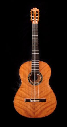 an acoustic guitar is shown against a black background, with the strings still attached to it