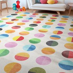 a living room with a white couch and multicolored rugs on the floor