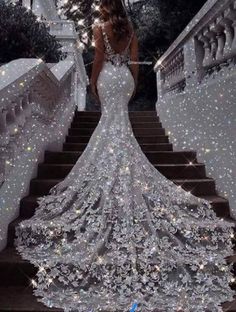 a woman standing on some stairs wearing a dress with sequins and sparkles