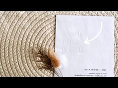 a piece of paper sitting on top of a rug next to a plant with the words save the date printed on it