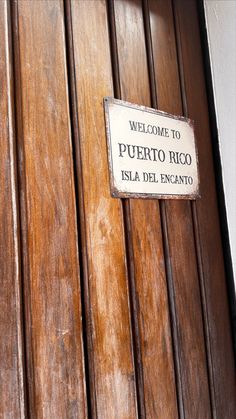 a wooden door with a sign on it that says welcome to puerto rico island del encanto