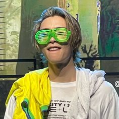 a woman wearing green sunglasses and a yellow jacket on the set of tv talk show