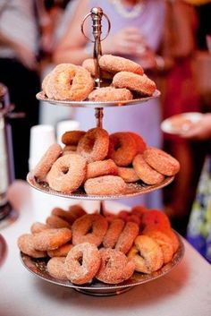 three tiered trays filled with donuts on top of a table