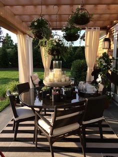 an outdoor dining area with candles and flowers on the table