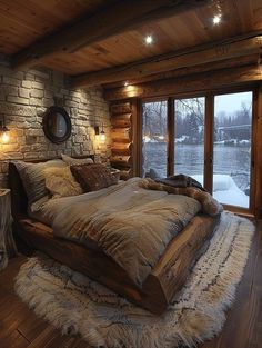 a large bed sitting in the middle of a bedroom next to a wooden floor and windows