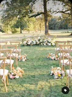 an outdoor ceremony set up in the grass with chairs and flowers on each chair for seating