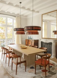 the dining room table is surrounded by chairs and an area rug that matches the fireplace