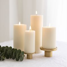 three white candles sitting next to each other on a table