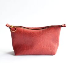 Introducing our Zipper Pouch – a versatile accessory perfect for countless uses! This design is the ideal blend of style and practicality for the minimalist who values both form and function. Crafted from premium full-grain leather, this piece is designed to be your go-to accessory for keeping your essentials close at hand. Plus, for added convenience, you can choose to include a wristlet strap as an additional add-on. Key Features: Elegant YKK Zipper pouch design Crafted from slouchy full grain Red Leather Enhanced with durable and stylish Brass Hardware Compact to fit nicely in our Totes + Bucket Bags, yet spacious enough for your essentials Measuring approximately 11" wide across top, 9” wide across bottom, 6" high, 3" deep Artisanal craftsmanship in Bellingham, Washington Questions? Co Pouch Design, Bellingham Washington, Bucket Bags, The Minimalist, Handbag Straps, Ykk Zipper, Stitching Leather, Accessory Organization, Brass Hardware