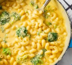 a pot filled with macaroni and broccoli on top of a checkered cloth