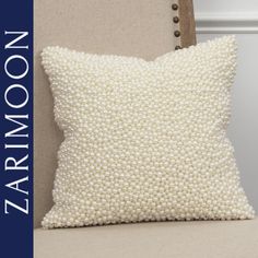 a white pillow sitting on top of a chair next to a wooden frame with the name aaron