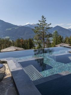 an outdoor swimming pool with mountains in the background