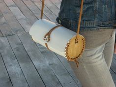 a woman carrying a white purse with wooden handles