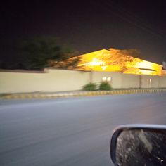 a building lit up at night on the side of a road