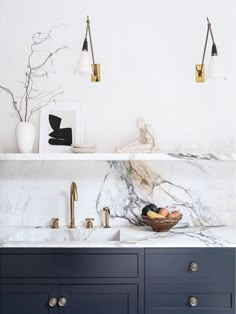 a kitchen with marble counter tops and brass faucets on the wall above it