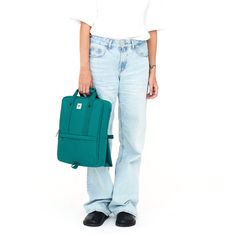 a woman in white shirt holding a green backpack