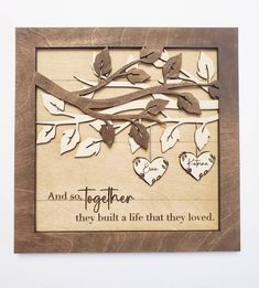 a wooden frame with hearts hanging from the branches and two words that say, and so together they built a life that they loved