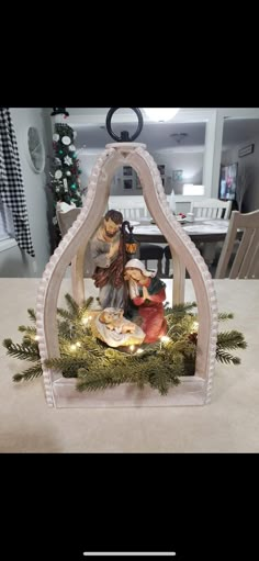 a nativity scene is displayed in the center of a table with christmas decorations on it