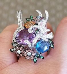 A beautiful big cluster multi color stones ring18 pieces Pink tourmaline weight 0.70 carat. 9 pieces of topaz weight 2.60 carats. 2 stones ( amethyst, citrine) total weight 6.60 Carats. 15 green garnets total weight 0.20 carat. 119 pieces of diamonds total weight 0.60 carats. 18kt White gold ring setting 14.50 grams. Multicolor Oval Amethyst Gemstone Ring, Elegant Multicolor Amethyst Ring For Anniversary, Elegant Multicolor Amethyst Gemstone Ring, Exquisite Multi-stone Cluster Ring Gift, Exquisite Multi-stone Gemstone Ring, Multi-stone Cluster Ring In Cubic Zirconia, Unique Multi-stone Cluster Jewelry, Multicolor Oval Multi-stone Cluster Ring, Exquisite Multicolor Multi-stone Rings