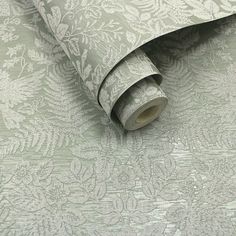 a roll of tape sitting on top of a wall next to a flowered pattern